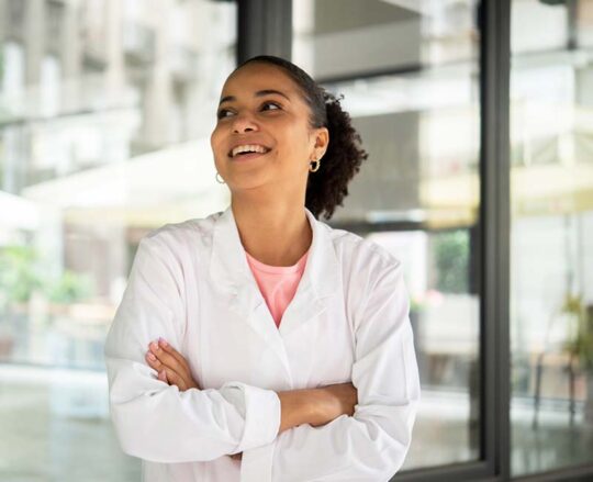 Young biomedical researcher smiling and crossing arms