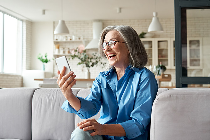 Mature woman in blue shirt using her phone