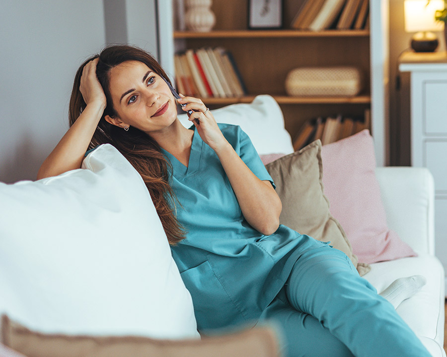 Nurse using her phone while sitting on her couch