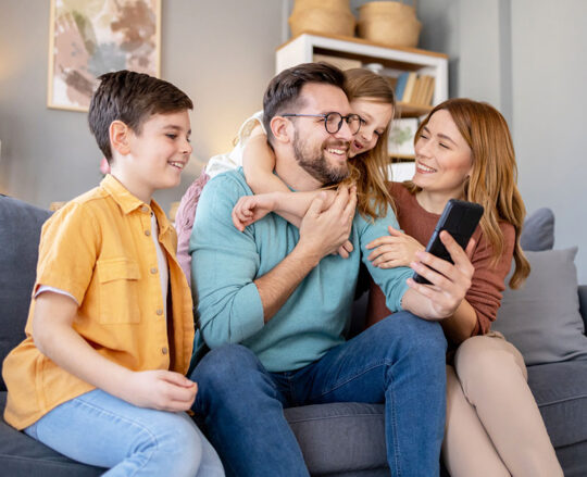 family in living room on cell phone
