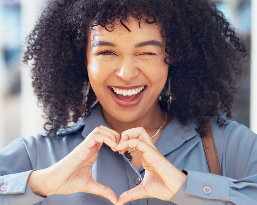 girl making heart gesture with hands